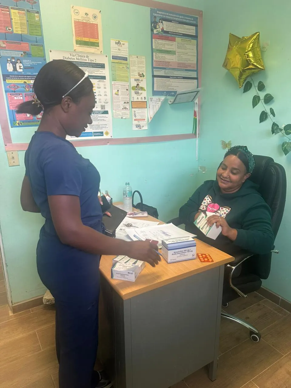 two women in medical office sorting through hygiene kits.