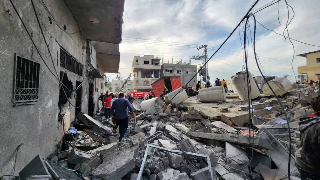 people walking through rubble in Gaza in daylight