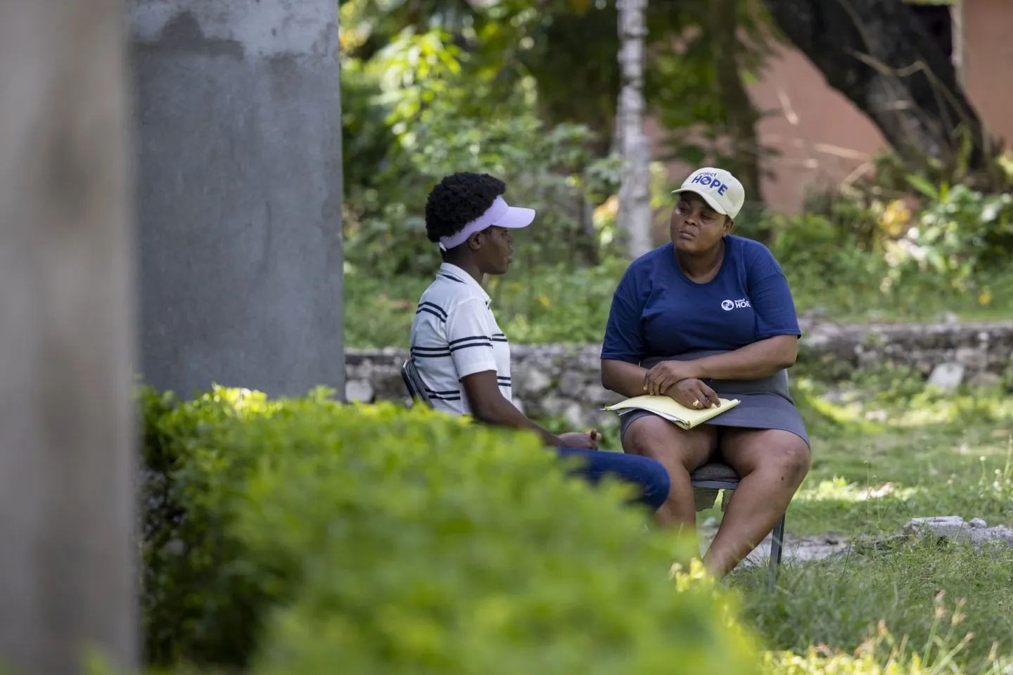 two people sitting outside and talking