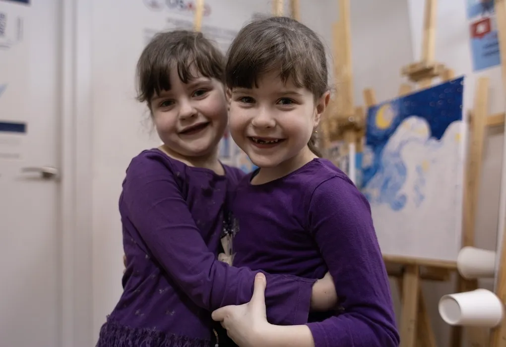 two young girls wearing purple dresses