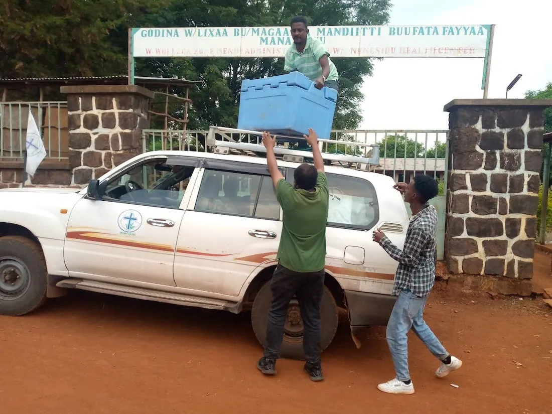 men unloading crate from car