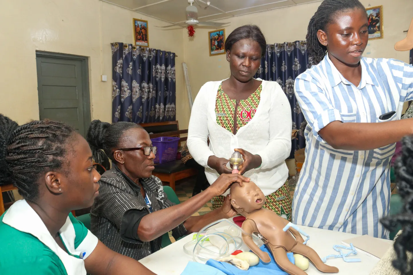 Four nurses learning to care for newborns