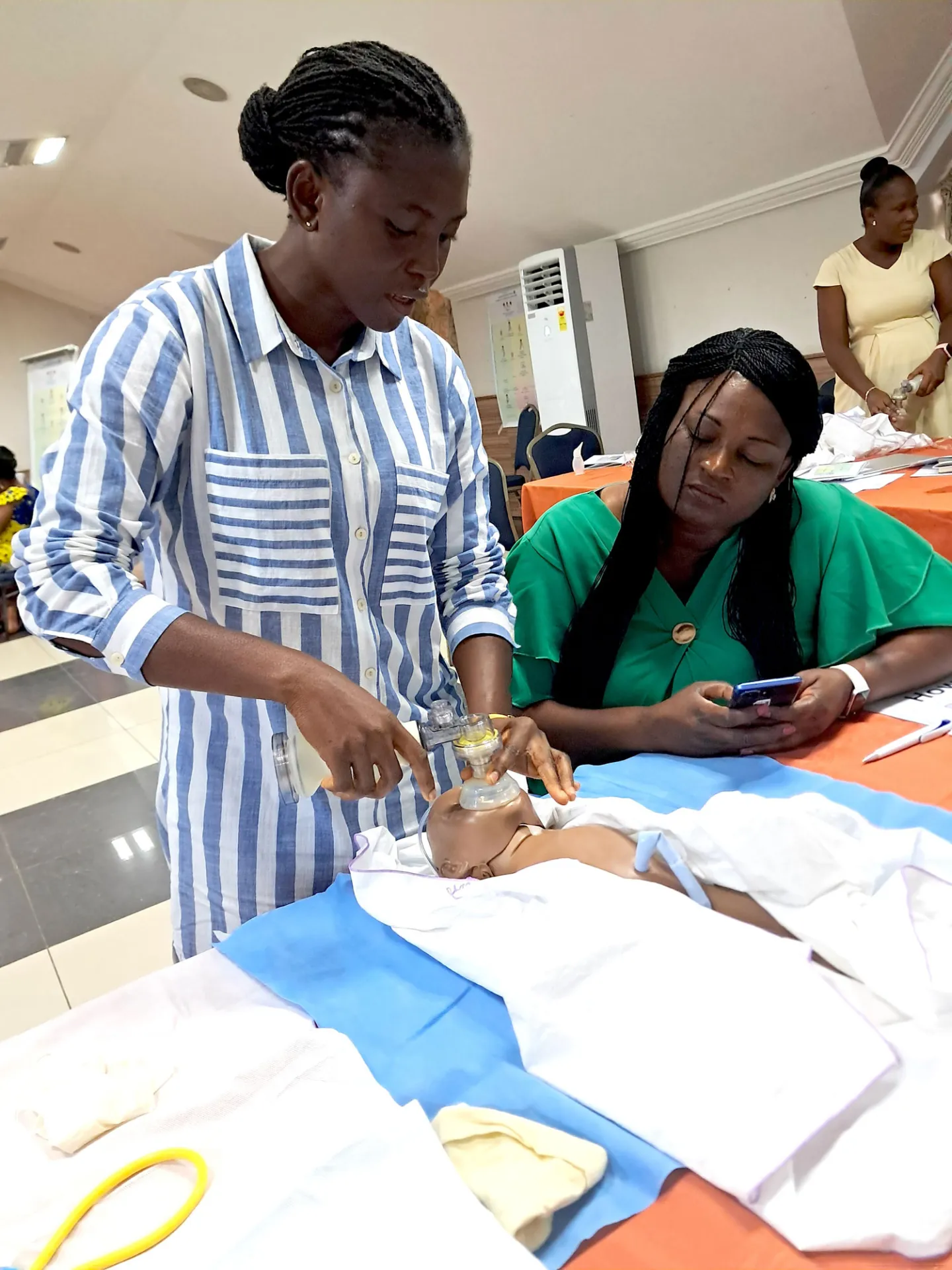 Two women learning CPR for newborns