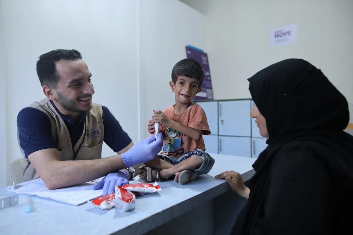 young boy getting food after suffering malnutrition in Gaza