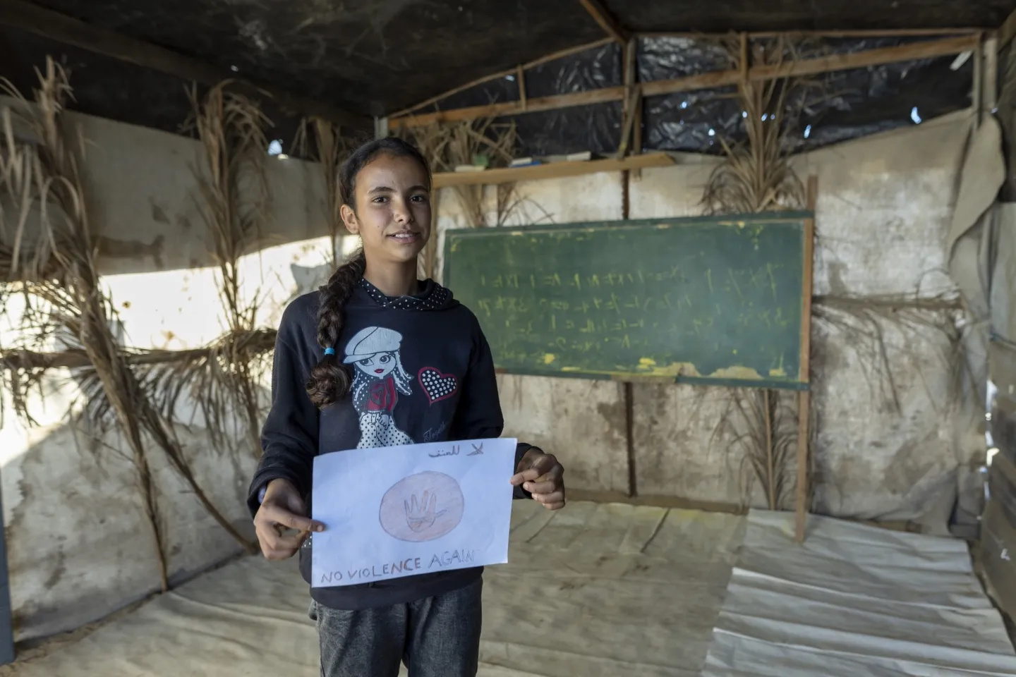 young girl holding artwork in Gaza