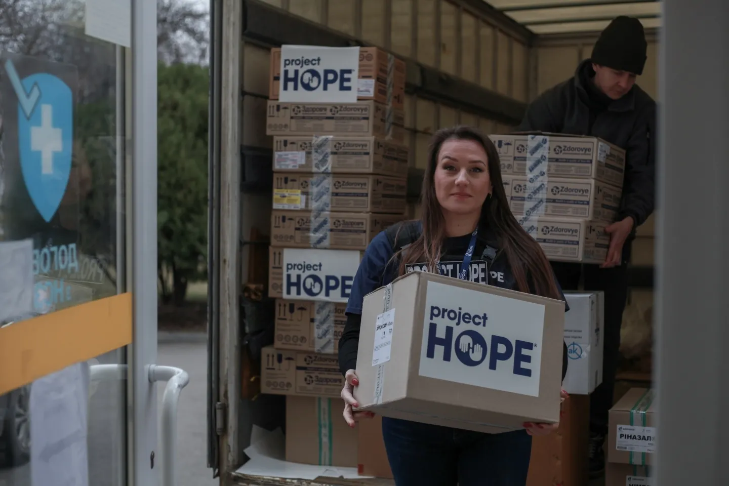 woman carries medical kits with Project HOPE labels on the front