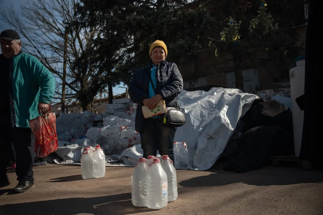 woman standing with water jugs