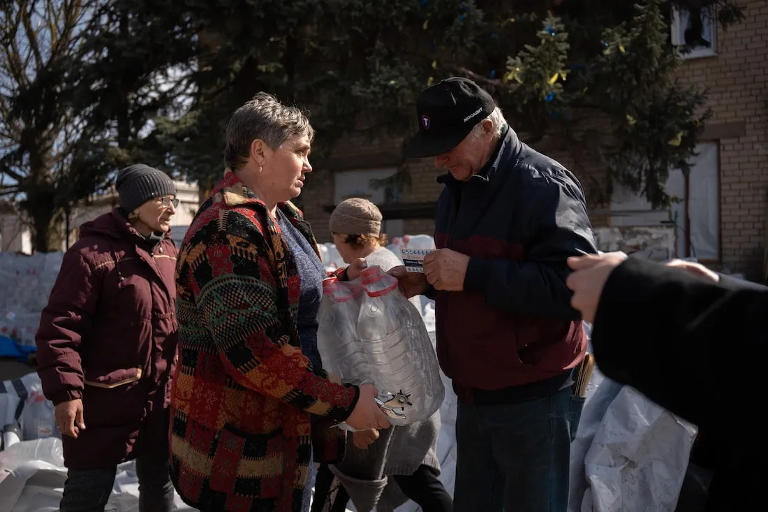 people exchanging water jugs