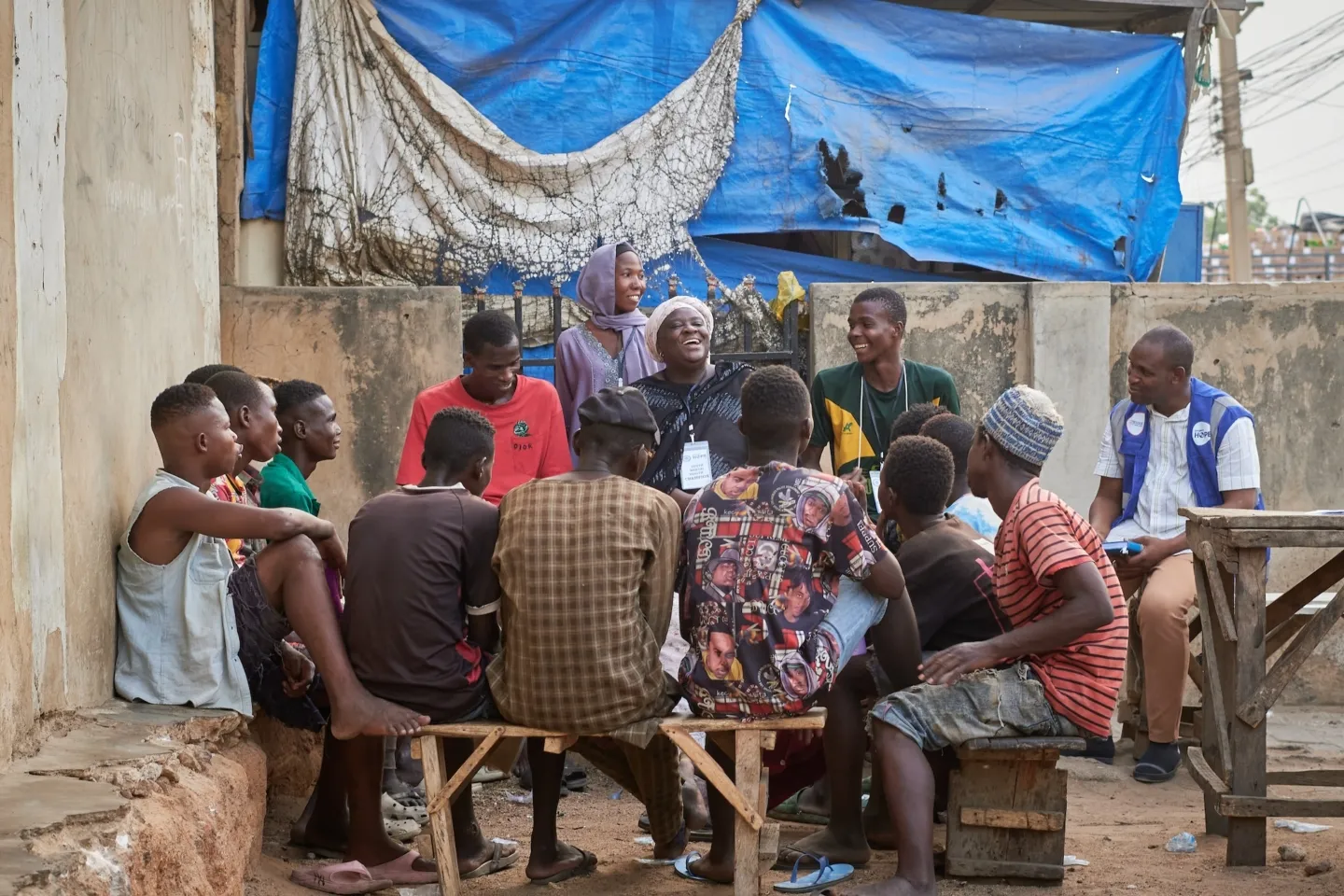 older woman speaks with young men in Nigeria