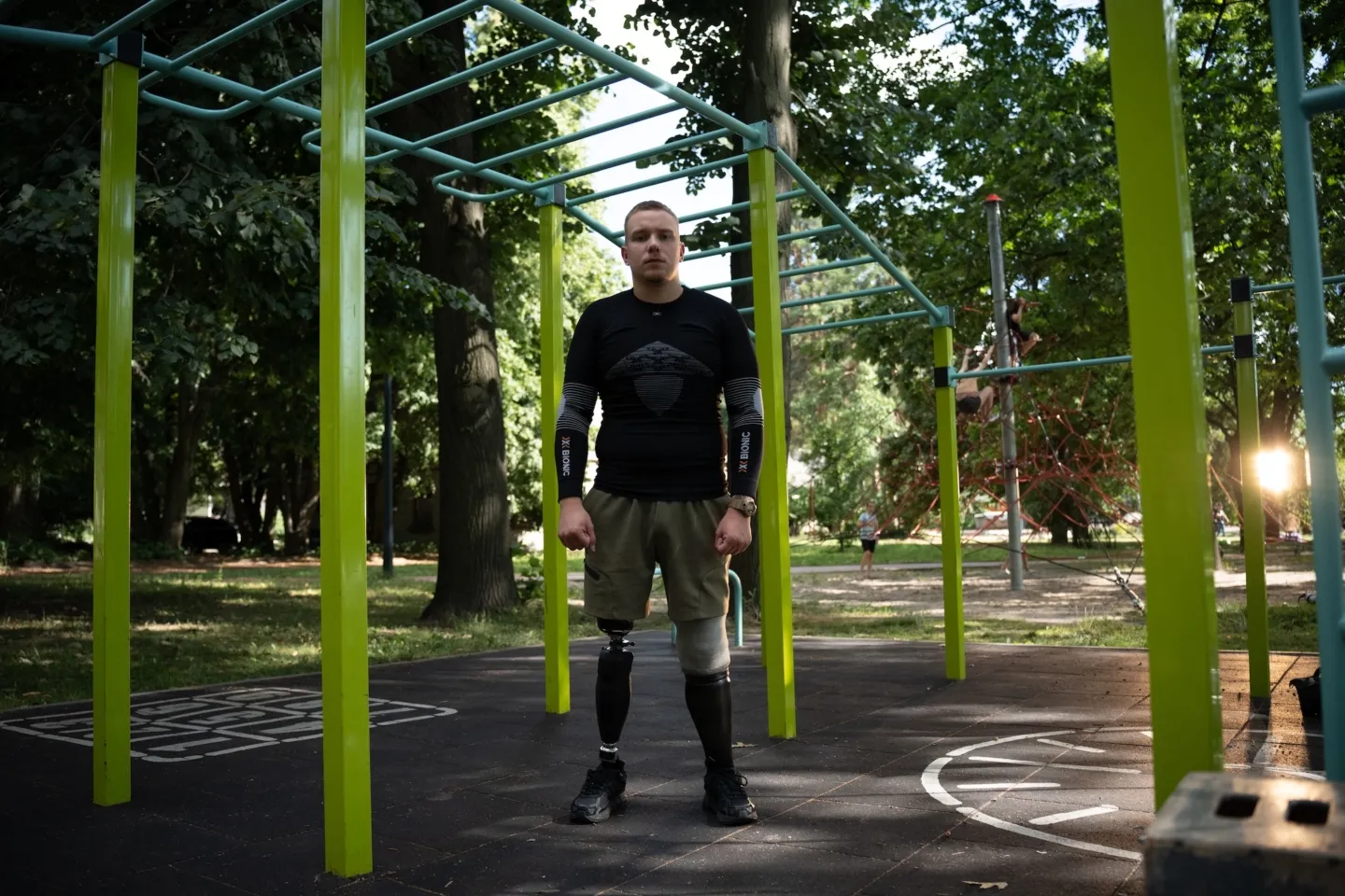 man stands in playground with amputated right leg