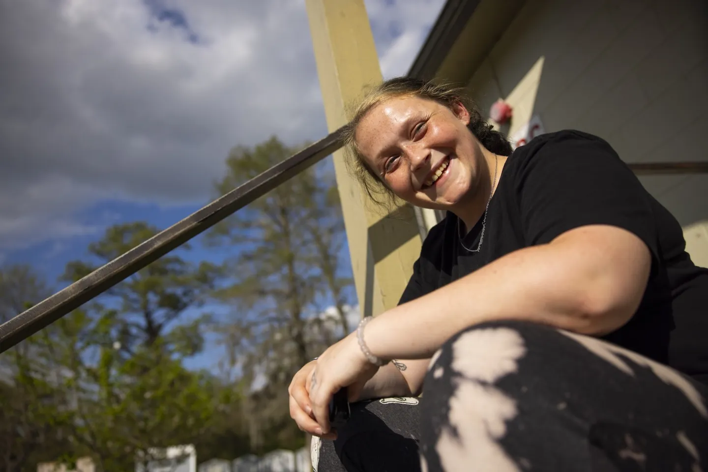 woman sits on steps outside of clinic