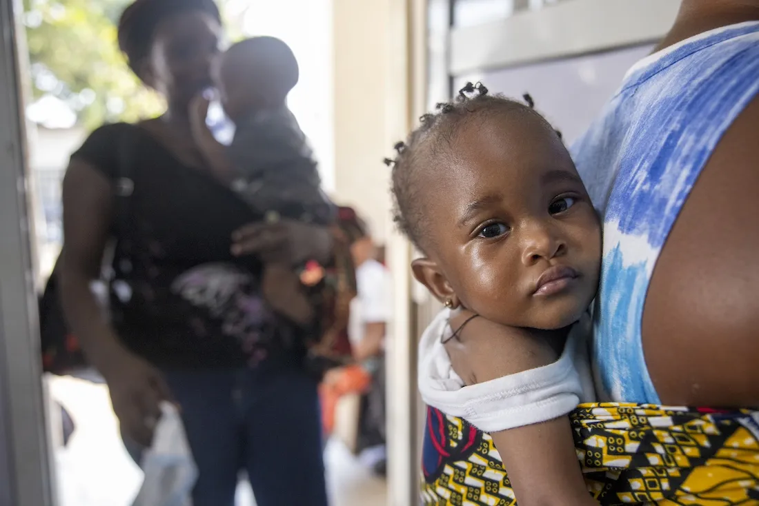 young baby strapped to back of mother