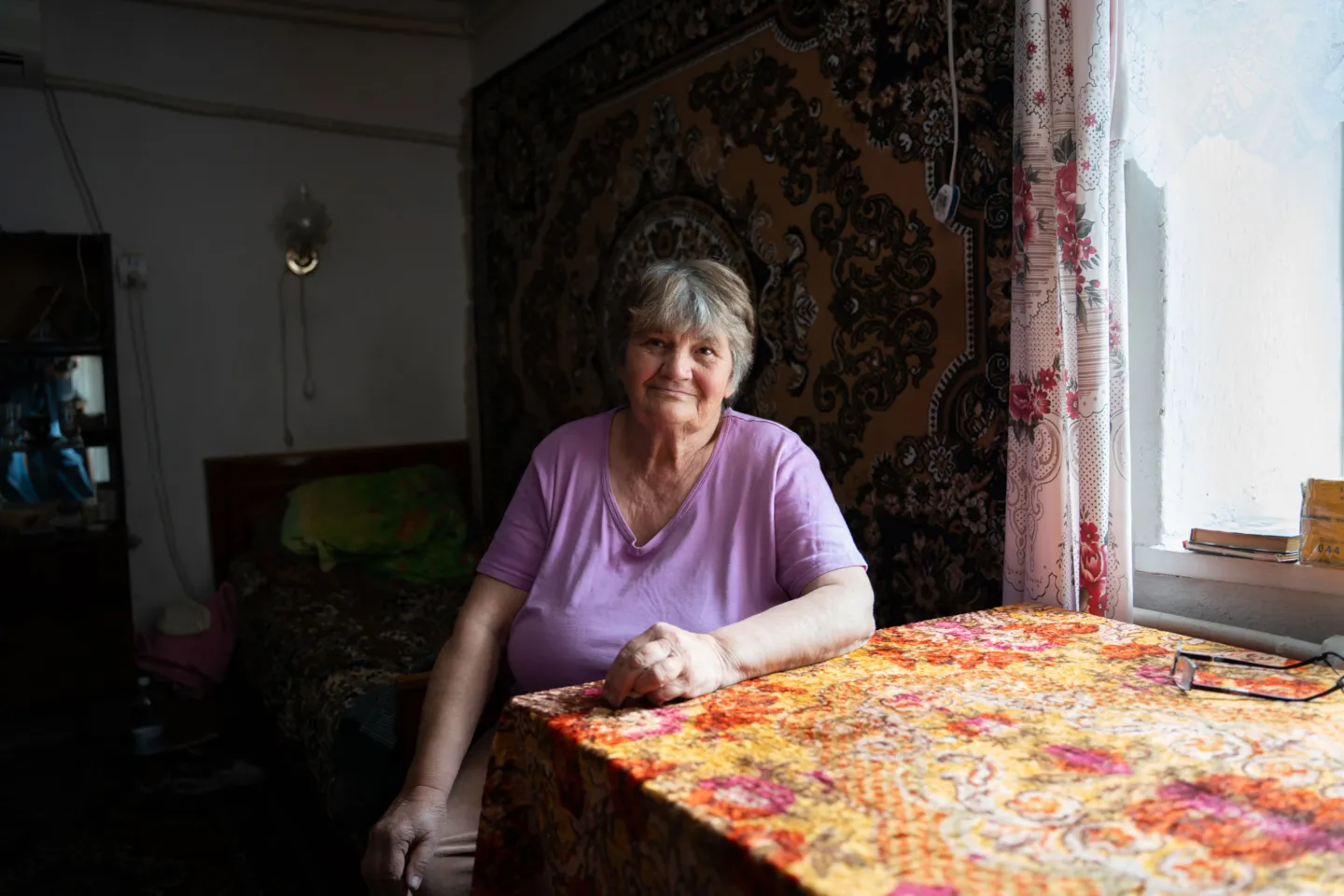 woman sits at table in her home in Ukraine