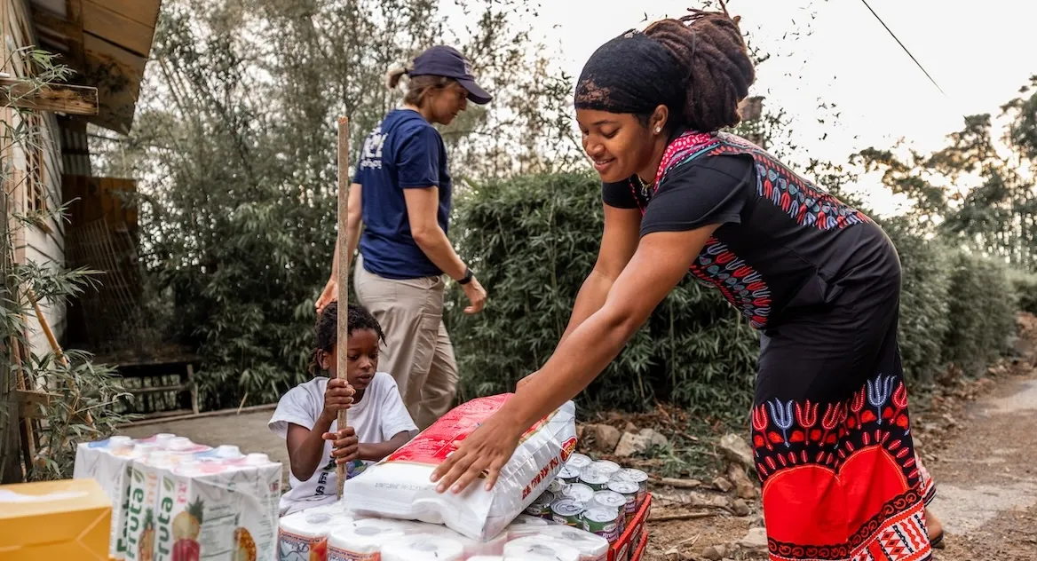 woman picks up supplies from a drop off in Jamaica after a hurricane hit