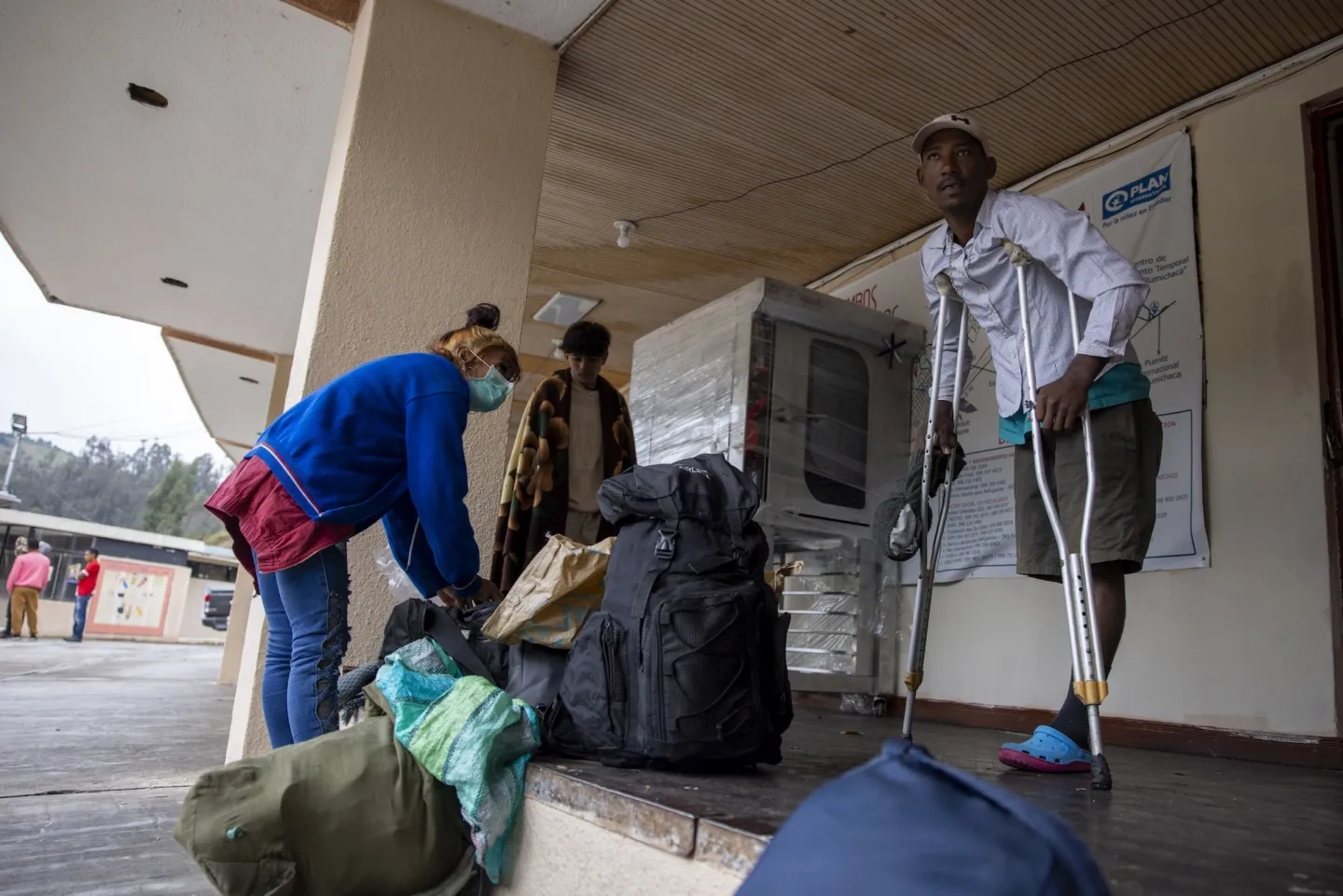man in crutches stands outside medical building