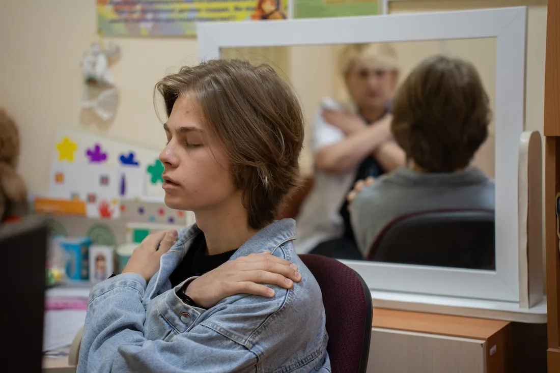 A person sitting in a chair with their arms crossed