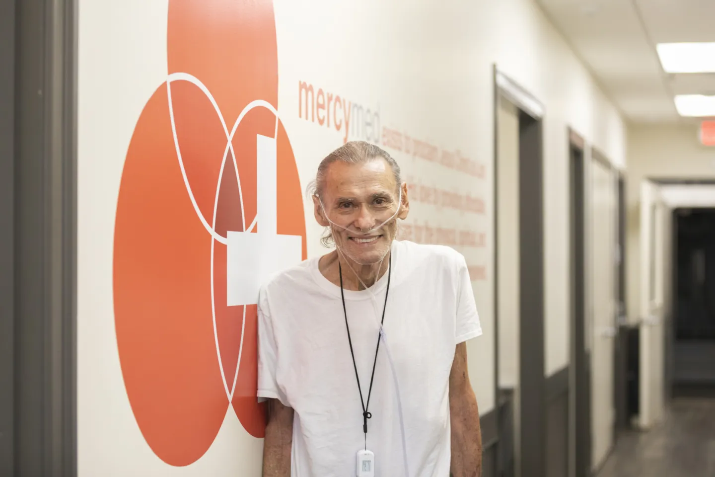 Elderly man with an oxygen line wrapped around his face