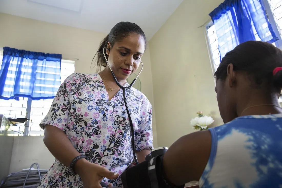 Medical nurse uses stethoscope on her patient