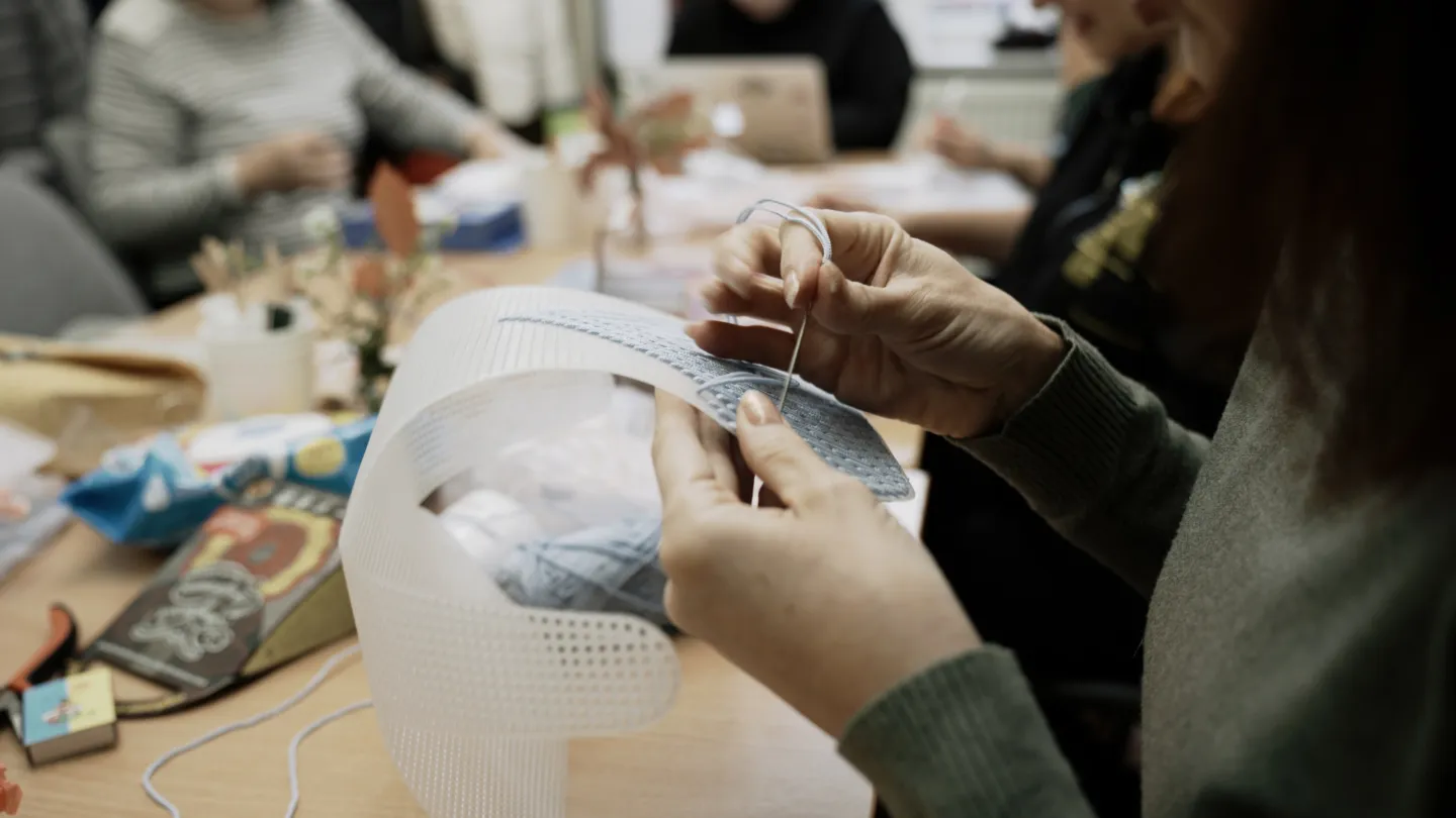 close up of woman doing needlepoint