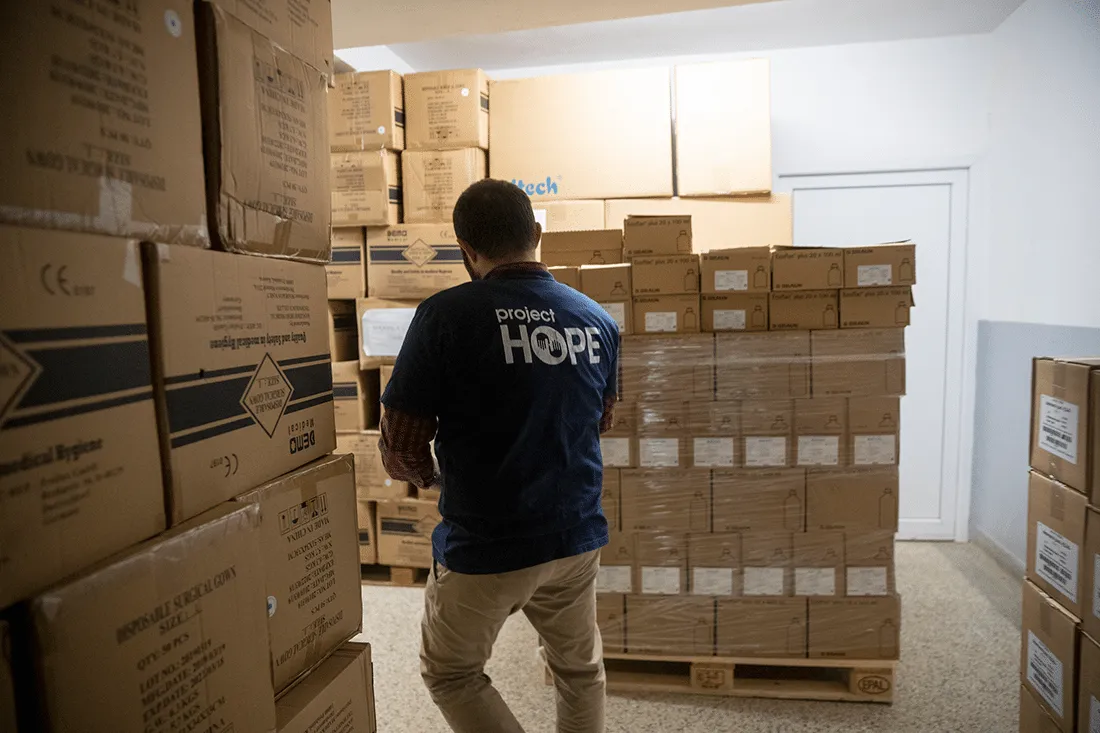 A man walks around a warehouse of medical supplies.