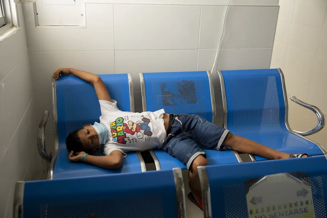 a boy laying across blue chairs