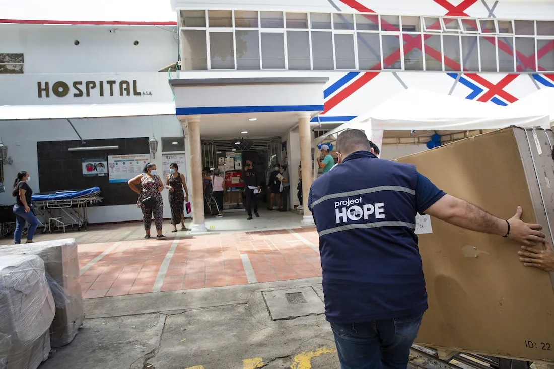 man carries medical equipment into hospital
