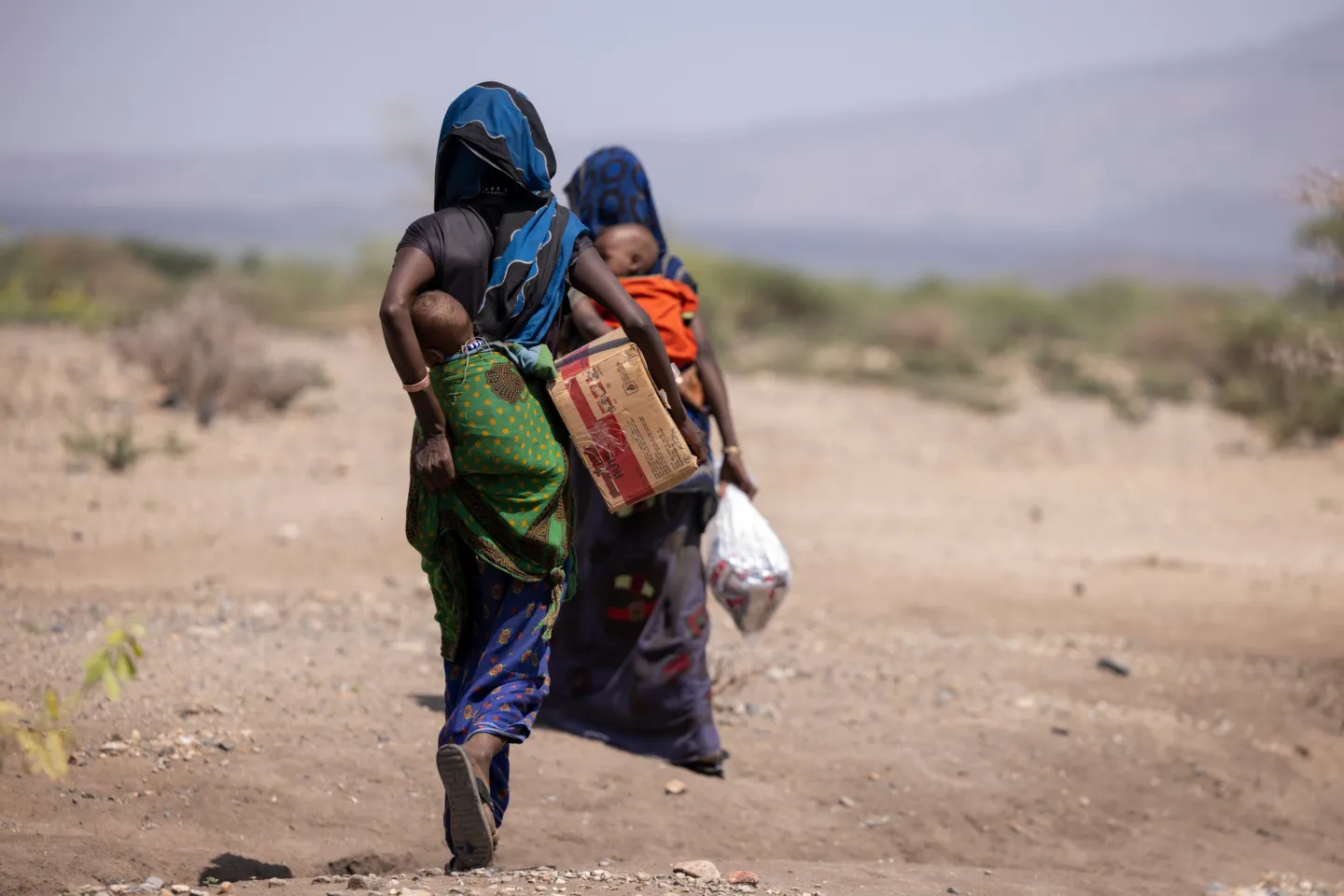 women carrying babies on their backs
