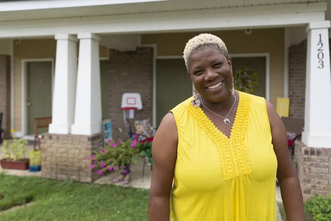 Felicia Carter posing in front of her home