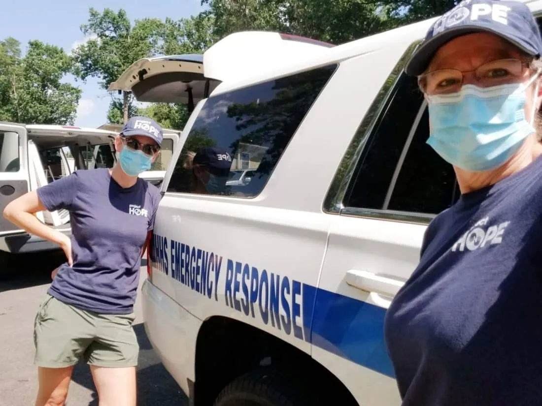 Two nurses wearing facemasks and Project HOPE shirts