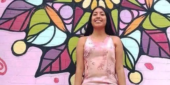 young girl in Mexico against a colorful brick wall